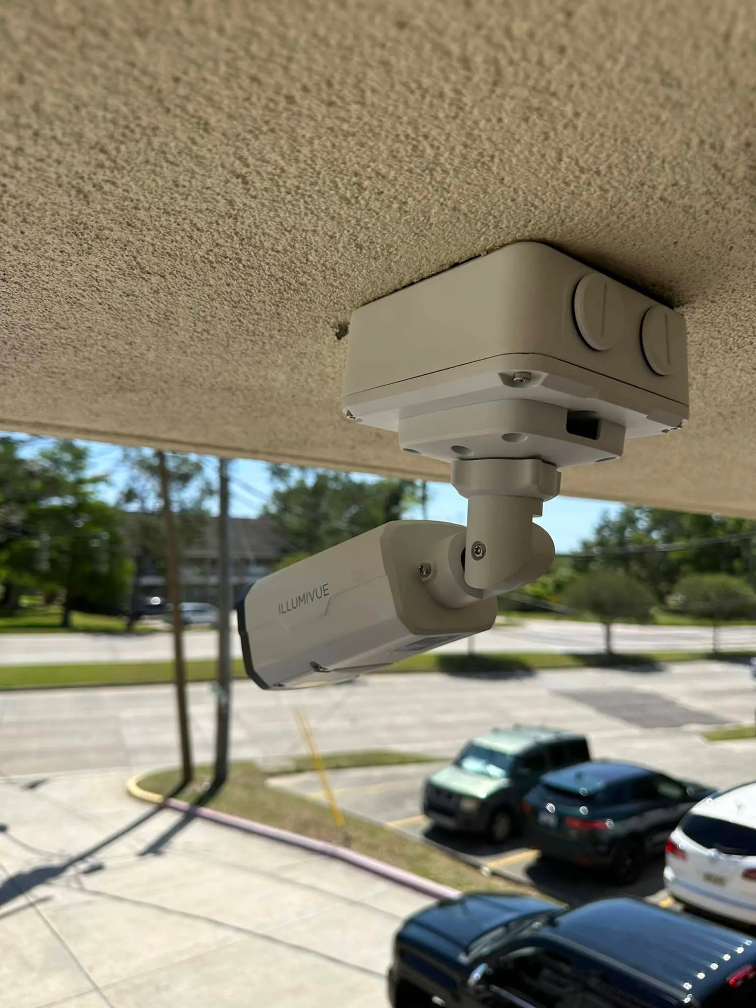 White Illumivue dome camera mounted under a roof eave.